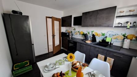 Helle, modern ausgestattete Küche mit Frühstückstisch und Dekor in frischen Farben in der Ferienwohnung.