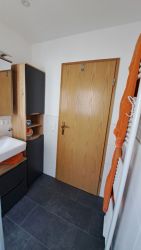 Badezimmer mit Holzdetails, Handtuchheizung und moderner Ausstattung in der Ferienwohnung.